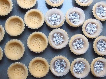 step14: 用叉子將完成的<span class="group_2">塔皮</span>底部叉出些許的小洞,以防盲烤時澎起。鋪一張小烘焙紙在<span class="group_2">塔皮</span>上,放入重石或紅豆。