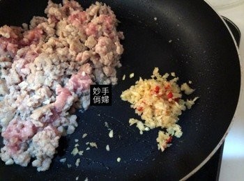 step6: 接著把豬絞肉撥到一旁,放下打好的蒜頭辣椒