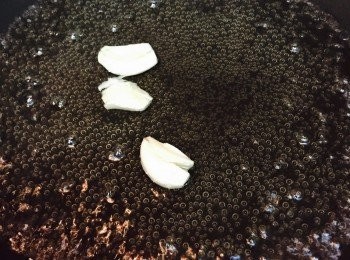step2: 燒熱白鍋放入已拍扁的蒜頭，炒香後加入白酒煮滾至酒精揮發。