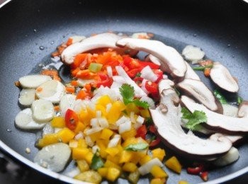 step6: 接著以少許的橄欖油，將蒜片、彩椒丁、辣椒丁、紅蘿蔔丁及香菇片下鍋爆香拌炒