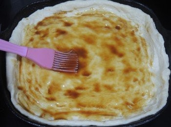 step7: 組合薄餅：
 預熱焗爐220度。紅洋蔥切細絲，取出薄餅，在中央塗上<span class="group_3">照燒汁</span>。