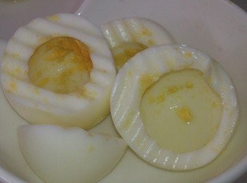 step5: 將煮熟雞蛋由尖頭部分切開，留下3顆，將蛋黃挖清，蛋黃與另外兩顆雞蛋切碎後放入沙拉盆中