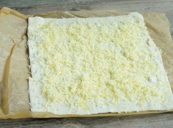 step1: 先在急凍酥皮上塗一層油 （煮食用的油：花生油，橄欖油等）可灑上鹽，黑胡椒粉和香料，然後灑上芝士碎，壓實