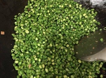 step5: 再加入2湯匙油，加入豆角及調味料略炒半分鐘，加入4-5湯匙水，上蓋，煮約1分鐘至8成熟，將午餐肉加入，略炒多半分鐘，即成。