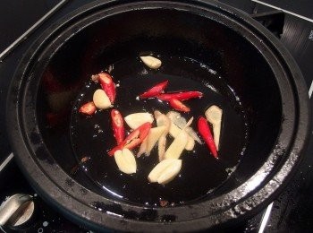 step4: 利用五花肉片的油脂,爆香蒜頭及辣椒薑片。