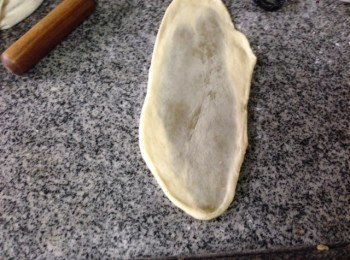 step5: 將水皮包完全包著油皮搓成球型用掌心按壓並從中心開始上下用麵棍桿平成