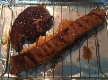 step3: 烤箱預熱到180度。 用鋁箔紙包住烤盤，烤架放上面，再把醃好的五花肉擺上，並沾些醃製的醬料塗在表面，入烤箱烤10分鐘後，