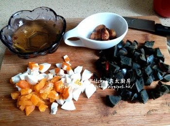 step7: 炸蒜頭的油亦盛起 , 蒸好的鹹蛋黃切粒 , 另一隻鹹蛋及皮蛋分別去殼切粒