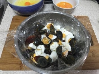 step5: 皮蛋和鹹蛋剝殼每顆各切小丁，準備一個有深度的容器，放上一層可以加熱的保鮮膜後，再加入皮蛋以及鹹蛋鋪平底部，再倒入調味後的晶米蛋白。