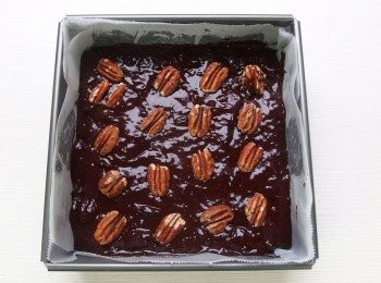 step16: 將麵糊倒入模型中,用刮刀抹平表面,撒上胡桃。放入烤箱以170度C烘烤20分鐘。出爐後連著烤模放在網架上降溫,冷卻20-30分鐘即可取出切成塊狀。