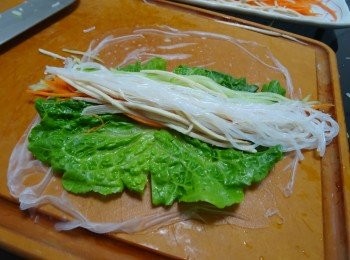 step3: 撈起米紙， 瀝去多餘水份，  放在砧板上， 小心將米紙將開（米紙太乾會黏著）, 放上生菜片,  適量札肉絲， 青瓜絲， 紅甘荀絲及檬粉， 小心捲成卷狀
切件便完成,