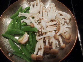 step2: 熱鍋後倒橄欖油及蒜頭,先放入鴻喜菇及美白菇拌炒一下,再將甜碗豆下鍋拌炒均勻受熱。