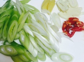 step2: 京葱洗淨去掉乾老的外層，切斜片。蒜頭切片，指天椒切斜片。蠔油、生抽和半湯匙米酒拌勻備用。