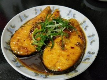 step6: 做法：

清洗三文魚後隔乾水份之後，大火起油鑊，將三文魚上少少生粉，放入煎香一邊，稍為收細少少火，煎至一邊少少挺身後，再反轉煎另一邊，再轉中火放入蒜頭，乾蔥，薑絲，麻油，生抽，蝦米辣椒油，雞粉，黃酒，少少水蓋好焗煮約 1 分鐘，將汁煮至濃厚，上碟放少少蔥花，完成。