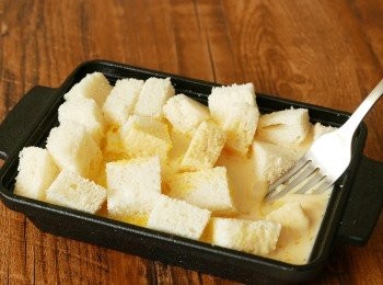 step5: 把布甸漿倒入步驟 2 中，輕加按壓或翻動麵包粒，讓麵包粒都均勻沾到布甸漿，靜置 5 分鐘。預熱焗爐到攝氏180度。