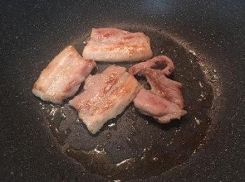 step2: 鍋裡用少許油先將五花肉煎出油並煎到兩面上色及可取出備用。（如用火腿只需煎出香氣即可）