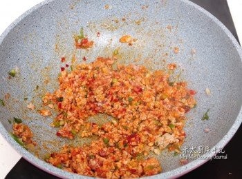 step3: 鑊中下橄欖油燒熱，放入豬肉快速地炒一炒，再加入薑米丶蔥花拌炒，並加入豆瓣醬混合。