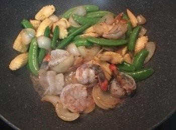 step4: 放入蝦球拌炒，下少許鹽和黑胡椒粉調味，再用米酒嗆炒。可適量加少許水以確保甜豆和蝦球煮熟。