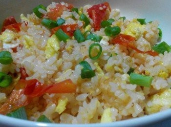 step2: 倒入橄欖油，放入隔夜飯炒一下，加入蕃茄，再把蛋放入，倒入少許塩巴、糖、胡椒粉、香油，最後放上青蔥，再小炒一下，即可呈盤上桌享用粒粒分明的黃金炒飯。
