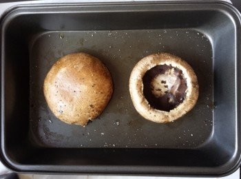 step1: 預熱焗爐200C.將大磨菇的腮刮淨及用沾濕的廚用紙巾抺淨大磨菇, 菇蒂切去留用. 撒上少許橄欖油, 鹽及黑胡椒. 磨菇面向上放入焗爐焗約10分鐘