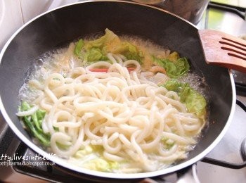 step3: 原鍋再放入1小匙油，將洋蔥絲、芹菜和茼蒿入鍋拌炒到軟後，放入烏龍麵和蝦肉蟹棒等海鮮料，再加入剛剛煮好的湯底及熱水，熱水的高度約淹過所有<span class="group_1">食材</span>即可