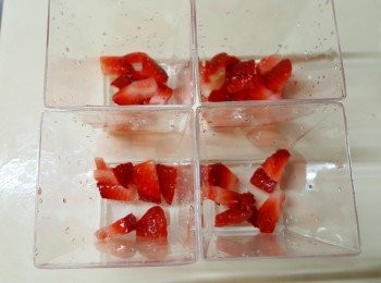 step4: 將部份士多啤梨粒放杯子內。