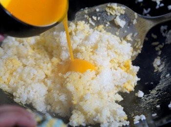 step5: 然後慢慢一邊加入蛋黃，一邊快手把白飯炒勻至金黃色。
