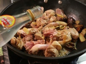 step6: 炒至鴨肉的表皮呈現金黃色後，倒入米酒，轉大火煮滾。