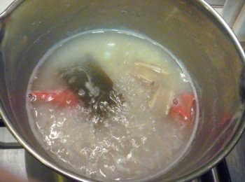 step2: 取小鍋子,放入柴魚昆布高湯,昆布乾,辣椒,薑片,干貝粉,鹽及步驟1的泰國香米煮滾,為了避免糊鍋用木鏟邊刮著鍋底邊加熱,煮至自己喜歡的稠狀.途中倒入2次冷水.