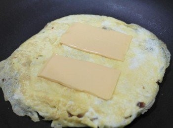 step6: 翻面!!! 撒上些許的白胡椒粉~~ 把起士片分成兩片鋪上!!!!