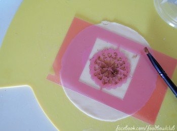 step2: 利用饼干模版制作优雅蕾丝图形（你可以设计任何的图案）。如果家里没有，那就自已动手吧 ～ 需要沾一点点的水涂在饺子皮上，然后再涂上薄薄一层的可可粉。这样，可可粉就比较容易沾粘不容脱落。