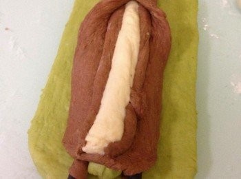 step8: 淨下的啡色麵團抽起60g, 餘下的用桿麵棍桿成長方形。60g 的啡色麵團分成2 份然而推成長條形, 白色麵團推成長條狀，然而將白色麵條指細放在綠色麵條上，啡色麵條排白色麵條兩旁。　從兩邊抽起啡色麵團將麵條包裹著 (如圖)