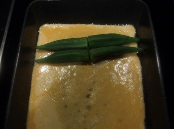 step2: 再放入已蒸熟的秋葵。當蛋汁邊緣熟了,用筷子將蛋皮捲起。捲起的蛋捲推至鍋子最前端,鍋子抹油後倒入蛋汁重覆捲起的動作,直到蛋汁用完。