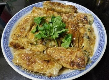 step15: 做法：

將韮菜清洗後切粒，用白鑊大火爆炒至出水份，隔乾水份備用。
雲耳用薑片，黃酒出水，再切成絲備用。
急凍蝦清洗後隔乾水份切粒，芫茜清洗後切碎備用。
將預備好的餡料用雞粉，魚露，糖，生粉，麻油，胡椒粉，雞蛋，少少糯米粉撈好，放入雪櫃冷凍 45 分鐘。
將腐皮對摺裁切成 12 塊三角形，將餡料用約 1 湯匙份量，放入腐皮包卷好，中火起鑊放入腐皮卷慢煎至金黃色，擺放上碟後，爆香蒜頭，乾蔥，薑絲加約 200ml 水，蠔油，糖，少少雞粉，少少生粉煮滾水，再將汁淋上面水滾蒸 6 分鐘，完成。