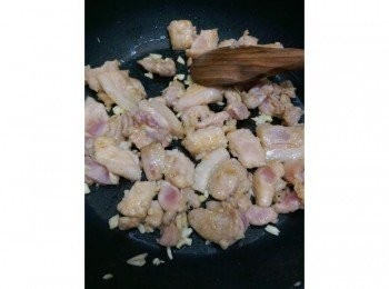 step2: 鍋子熱了之後，倒一點點的油（不放多是因為醬料裡面已含有麻油），切碎的蒜頭倒進去拌炒一下再把肉片倒進去平鋪，中火煎到焦黃至熟。因為蔬菜只需要拌炒個三分鐘，所以肉一定要熟。