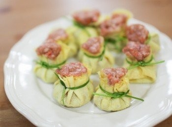 step6: 燒賣包好後，用水蓮菜打一個可愛的小結以固定蛋皮