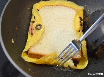 step10: 一邊中火煎用工具扶邊讓蛋皮包裹吐司約煎五分鐘