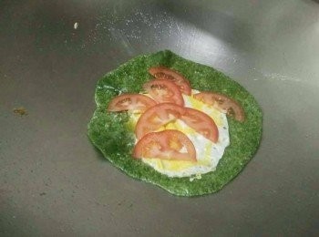 step2: 倒入橄欖油，熱鍋，蛋放入油鍋，接著把海菜餅鋪在蛋上面，煎40秒後翻面，擺上7小片蕃茄，轉小火稍煎一下；