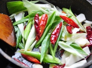 step4: 接著放入乾辣椒、大辣椒、算段、薑片、蒜片爆香翻炒