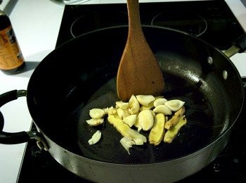 step2: 熱鍋加入麻油，放入薑片用中小火慢慢煸香薑片，接著加入蒜頭炒出香氣。