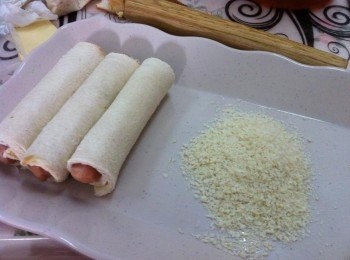 step1: 首先把吐司四角去皮，然後壓扁卷上香腸和芝士，利用蛋汁做收口靜置5分鐘