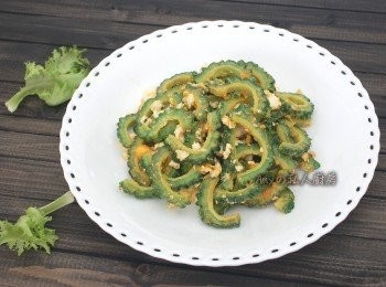 step1: 先將翡翠苦瓜剖半,用湯匙挖除種子及白膜(會苦的部份)再切成片狀。去除苦味秘訣之一:將切好的苦瓜片放入保鮮塑膠袋裡再放入一匙鹽,隔著袋子稍微揉搓一下靜置3-5分鐘,再用清水沖洗乾淨。鹹蛋去殼後,將鹹蛋白及鹹蛋黃分別用叉子壓成碎狀。