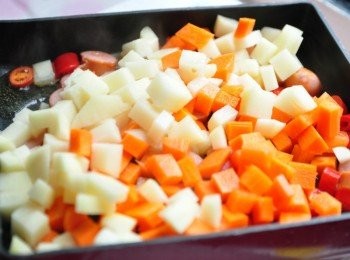 step3: 接著放入洋芋及紅蘿蔔丁入鍋拌炒略悶煮片刻