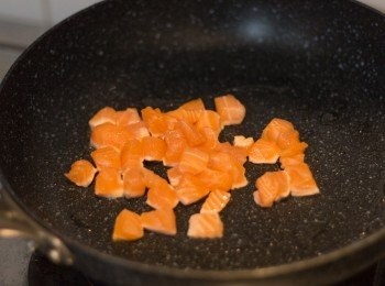 step2: 開中細火燒熱鍋下少許油，油熱後下三文魚粒略炒，只要表面轉色就可以盛起備用，不用全熟