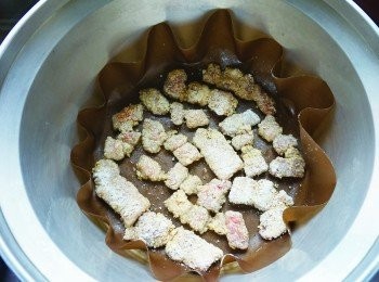 step4: 在烘焙紙上抹上薄薄一層油放上2 的肉片，蓋上鍋蓋煎到開關跳起後，在表面抹一層油並翻面。等全部肉片翻好後，再按下開關，將另外一面也煎成金黃色就完成了