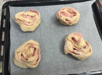 step7: 之後將麵團從切口處翻開，切面向上，放在已鋪上烘焙紙的烤盤上，再蓋上保鮮紙，做二次發酵40分鐘 －1小時