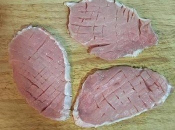 step2: 用刀在豬里肌肉上劃刀痕，兩面都要，不需要劃穿，以便烹煮。 洋蔥切條狀備用。