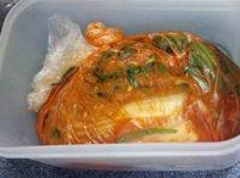 step6: E.拎個保鮮袋鋪在碟上，然後將白菜葉一片片平鋪在保鮮袋上，鋪完擠出保鮮袋的空氣令白菜葉都接觸到腌料，扎實袋，放入可密封的保鮮盒中！放置室溫1日，然後擺入雪櫃慢慢發酵4-5日！