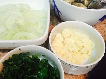 step1: 沙白蜆先放沙洗淨備用。西班牙香腸切片或切粒皆可。蒜頭切片，洋蔥泡水後切絲。香芹（Parsley）莖部切碎，葉略切即可。