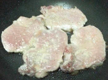 step7: 另備鑊子煎豬扒。熱鑊下油，慢火煎至豬扒兩邊熟透。在豬扒8成熟時，可加入牛油增添風味。